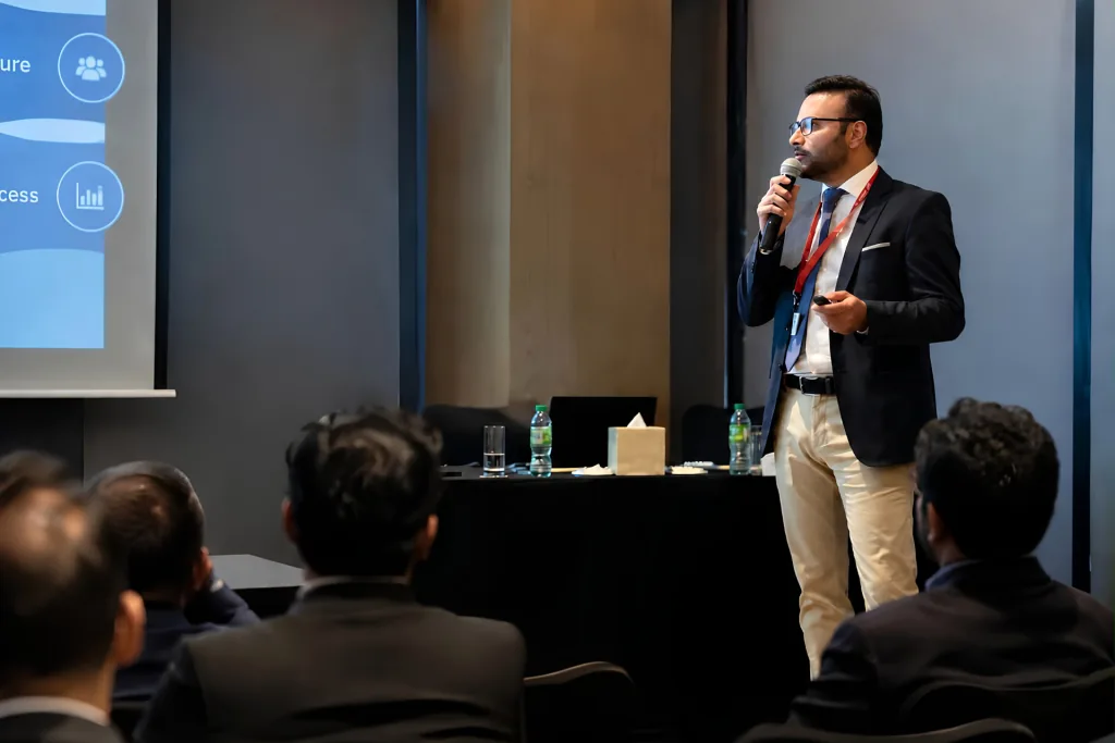 Prof. Dr. Sami Hassan speaking with a microphone to a seated audience