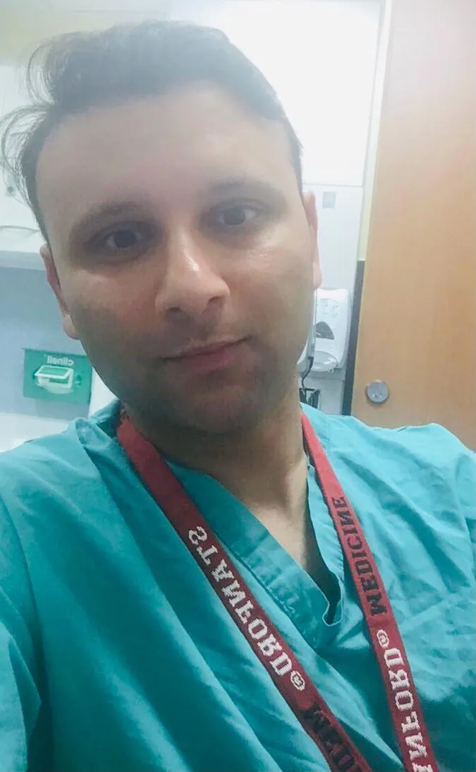 Prof. Dr. Sami Hassan in theatre scrubs wearing a Stanford Medicine lanyard