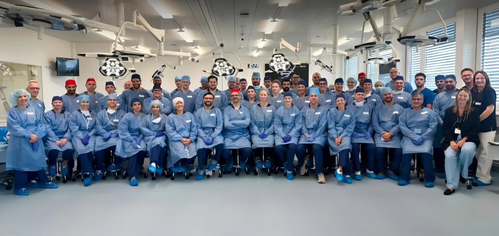 Prof. Dr. Sami Hassan with surgeons in theatre gowns at a hands-on surgical training course in a training lab