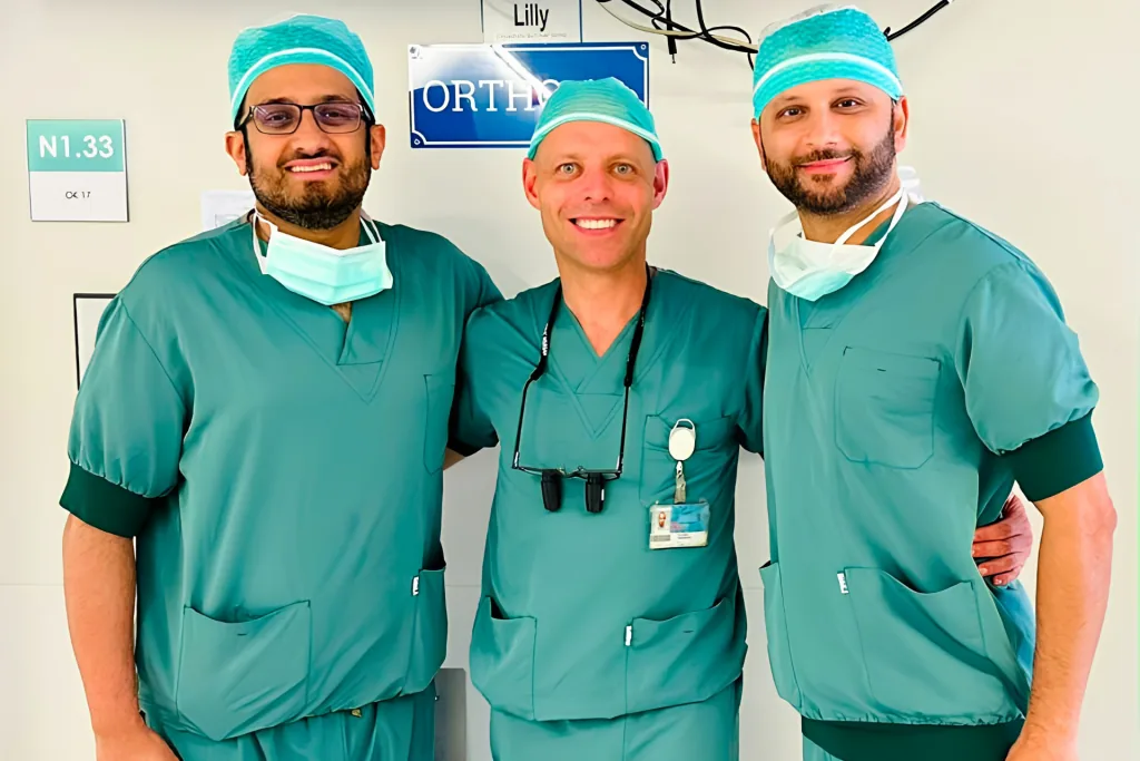 Prof. Dr. Sami Hassan in green theatre scrubs with two surgical colleagues