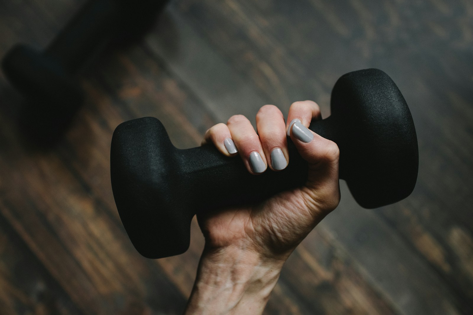 Close-up of a hand and wrist holding a black dumbbell