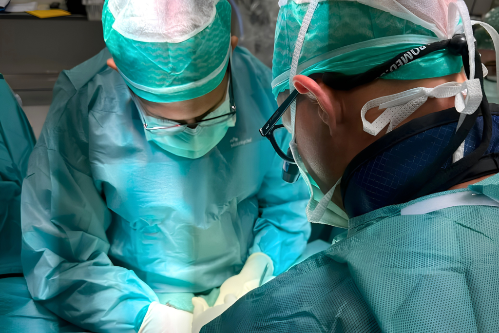 Two surgeons concentrating during an operation, with the operative field out of view